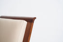 Close-up detail of an Art Deco Streamline Moderne armchair corner, showing a cream-colored leather or fabric seat cushion and a curved dark brown wooden frame against a plain white background.
