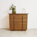 Vintage Art Deco teak wood dresser with decorative items on a white background