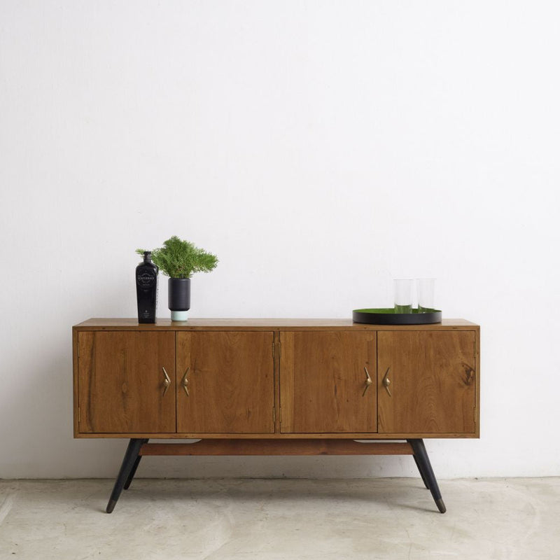 Vintage wooden sideboard with decorative items against a white wall